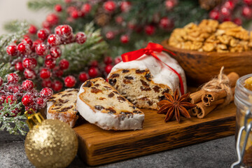 Obraz na płótnie Canvas Christmas stollen on wooden background. Traditional Christmas festive pastry dessert. Stollen for Christmas.Christmas fruit cake, pudding on a white plate.Traditional German Christmas pastry.
