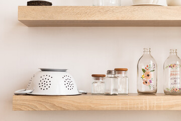 Fototapeta na wymiar kitchen utensils in a kitchen, shelf with bottles and colander