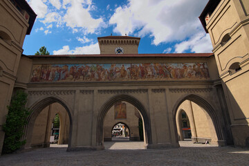 Fototapeta na wymiar Wide-angle landscape view of the ancient Isartor Gate. Located at the Isartorplatz in Munich, Germany in Munich. It is one of the four gates for entering the medieval city. Travel and tourism concept
