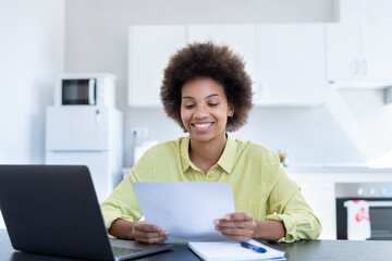Happy smiling remote working young black female receive postal letter from company office about...