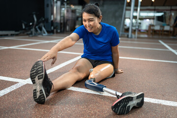 Happy Asia woman with prosthetic leg exercise at gym or fitness	