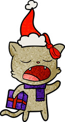 Fototapeta na wymiar hand drawn textured cartoon of a cat with christmas present wearing santa hat