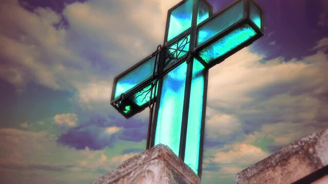 Religious Glass Cross Sculpture Cloudy Sky Tilt Up. Blue glass cross sculpture on top of building, cloudy sky in the background. Religious Symbol