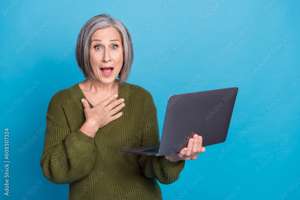 Sticker Photo of astonished person bob hairstyle wear knit pullover hold laptop arm on chest impressed staring isolated on blue color background