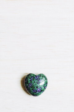 Pierre polie rubis zoisite en forme de coeur sur un fond blanc