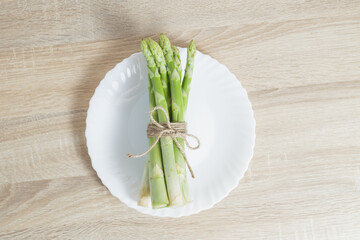 vegan food. asparagus on a white plate in a bright kitchen