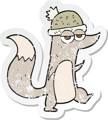 retro distressed sticker of a cartoon little wolf wearing hat