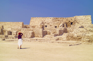 Visitor Being Impressed with the Remains of Qal'at al-Bahrain, UNESCO World Heritage Site in Manama of Bahrain