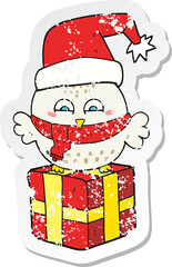 retro distressed sticker of a cartoon cute christmas owl on gift