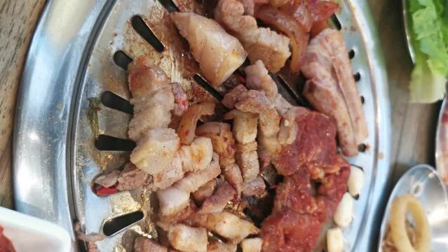 Korea bbq, Pork grilled. concept of Korean or Japanese local food. A delicious or yummy pork grilled. A hand picking up a piece of pork grilled Hot and fresh lunch. Vertical BBQ video. Home party meal