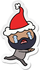 hand drawn sticker cartoon of a bearded man crying wearing santa hat