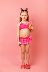 Cute little child in beachwear on pink background