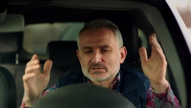 Senior driver is getting nervous because of the car traffic. Bearded man in car is mad