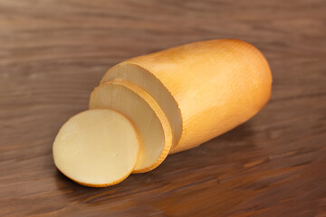 Provolone cheese with cut slices on top of beautiful wood