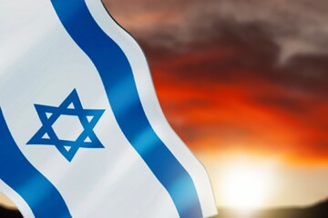 Israel flag over sky background on sunset.