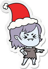 annoyed hand drawn sticker cartoon of a vampire girl wearing santa hat
