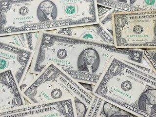 Several $1 and $2 Bills Close Up on Surface