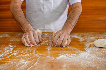 Baker kneading artisan bread in the bakery.