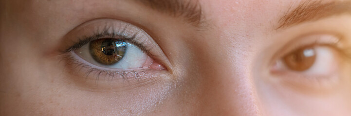 Young woman face with brown eye close up view. Macro photography of female eyes selective focus.