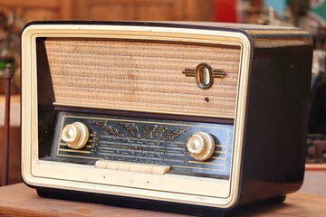 Retro broadcast radio receiver on wooden table circa 1950