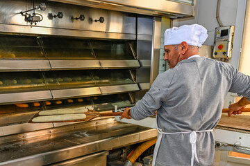 Baker baking fresh bread in the bakery.