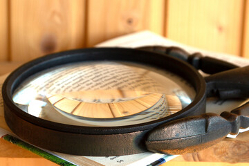 A large magnifying glass lies on an open book
