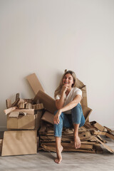 Young woman wand stack of cardboard waste at home. Concepts of Paper Recycling and Waste Sorting