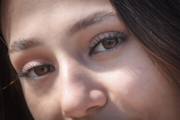 Obraz premium Close up of a beautiful woman's face with brown eyes and long eyelashes