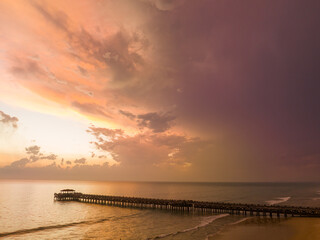 Obraz premium aerial view amazing cloud in colorful sky at sunset above the ocean..The bridge plunges into the sea water reflected from the sky..Majestic sunset landscape Amazing light of nature cloudscape sky..