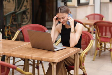 Successful young woman student, freelancer has stress with comunicating at smartphone during works...
