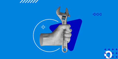 Adjustable wrench in man's hand on blue background for workshop design, repair and construction...