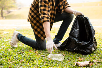 Closeup image of a hand picking up trash on World Environment Day,  showcasing our dedication to...