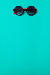 luxury fashionable sunglasses on blue or turquoise background, flatlay top view
