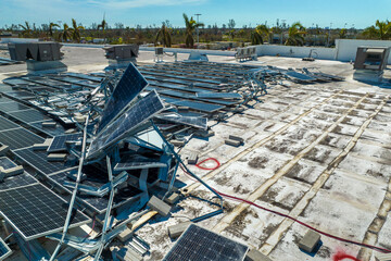 Broken down photovoltaic solar panels destroyed by hurricane Ian winds mounted on industrial...