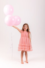 Obraz na płótnie Canvas People, joy, fun and happiness concept. Relaxed happy birthday little girl celebrating cheerful, smiling happily, posing for picture, holding colorful helium balloons