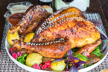 Roasted chicken in pomegranate sauce with potatoes in a gray ceramic mold. Dark background. Top view. Copy space