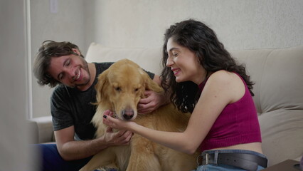Heartwarming Moments_ Affectionate Couple Engaging in Playful Interactions with their Beloved Golden Retriever on Sofa at Home