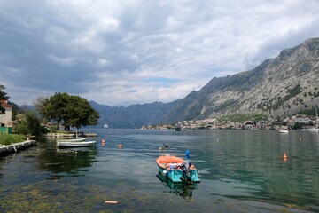 Naklejka premium View of Bay of Kotor with buildings of Kotor and standing big cruise ship by coast from tourist rail on Vrmac Peninsula, with the highest peak Sveti Ilija. Montenegro, Balkans