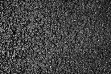 Black texture of asphalt pavement with stones with stones. Black bituminous waterproofing.Bituminous asphalt stones, bitumen chips close-up.