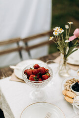fresh whole strawberries in a glass transparent plate. strawberries in a vintage crystal bowl. strawberries in a dessert bowl close-up.
