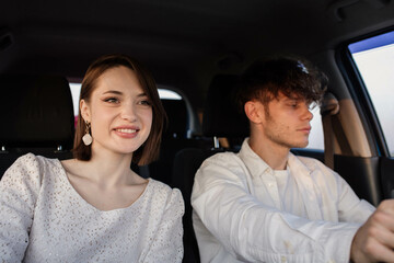 positive couple in love ride in a car on a trip to a date on a sunny day