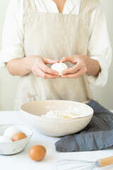 Cooking eggs with women's hands in a bowl of flour. Making a delicious breakfast. 