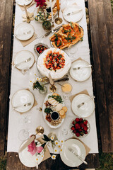 top view of the served table with snacks. decorated table with white tablecloth and plates