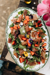 big dish with gourmet salad top view. details of summer outdoors picnic snack.