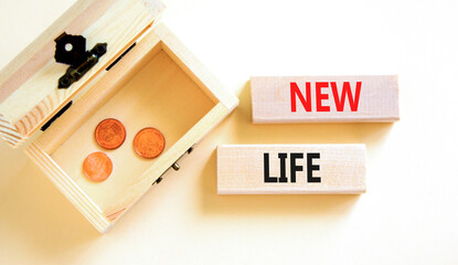New life symbol. Concept words New life on wooden blocks on a beautiful white background. Wooden chest with coins. Business, support, motivation, psychological and new life concept. Copy space.
