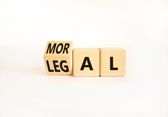 Obraz premium Legal or moral symbol. Businessman turns wooden cubes and changes the word Legal to Moral on a Beautiful white table white background. Business and Legal or moral concept. Copy space.