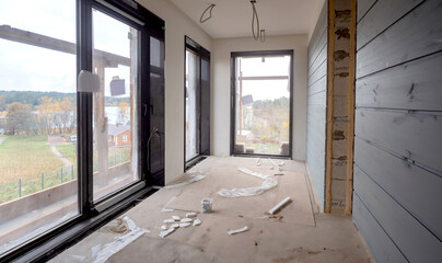 Building under construction. Unfinished country house from inside. Room with construction debris on...