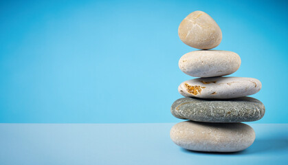 Fototapeta na wymiar Balanced zen stones on abstract blue background