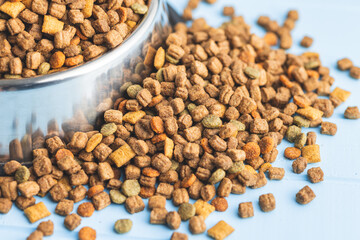 Dry kibble pet food. Dog or cat food on blue table.