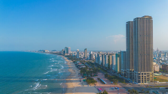 Aerial sunset view of Da Nang coastline. My Khe beach seafront with high-rise hotels and skyscrapers in the golden sand beach